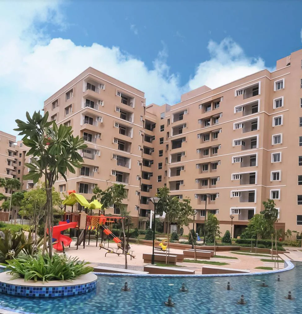 Apartment towers around a pool and children’s play area at Brigade Orchards, Devanahalli, photograph