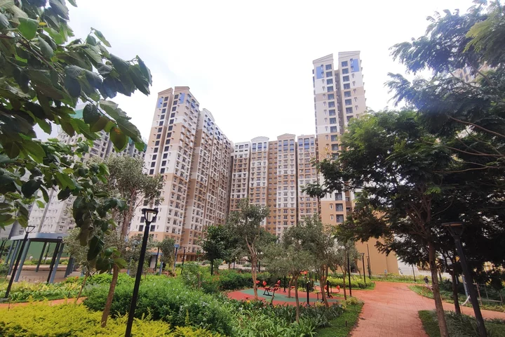 Apartment towers above a landscaped garden path at Brigade El Dorado, photograph